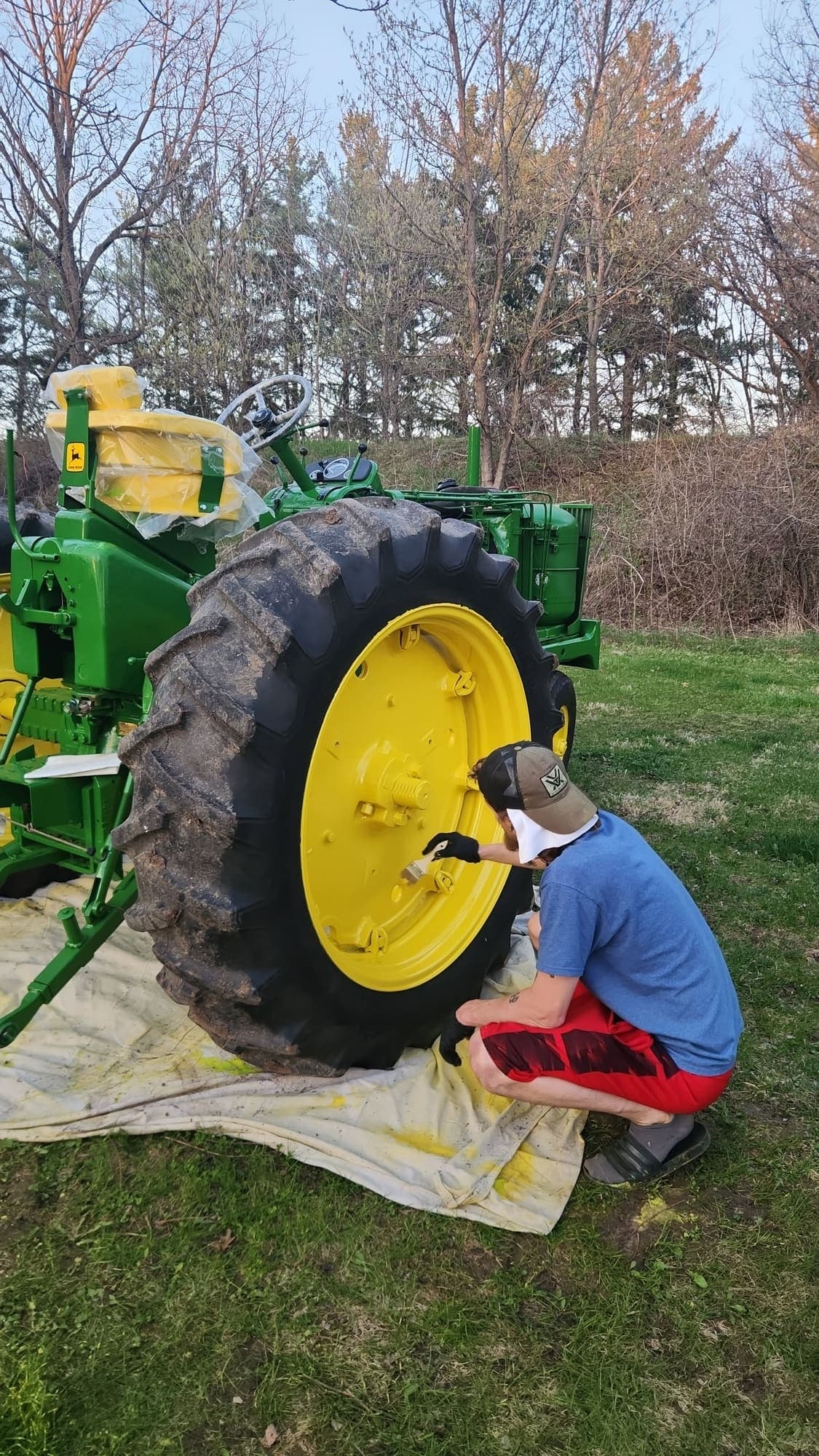 Hand-painting a John Deere rear rim in fresh yellow