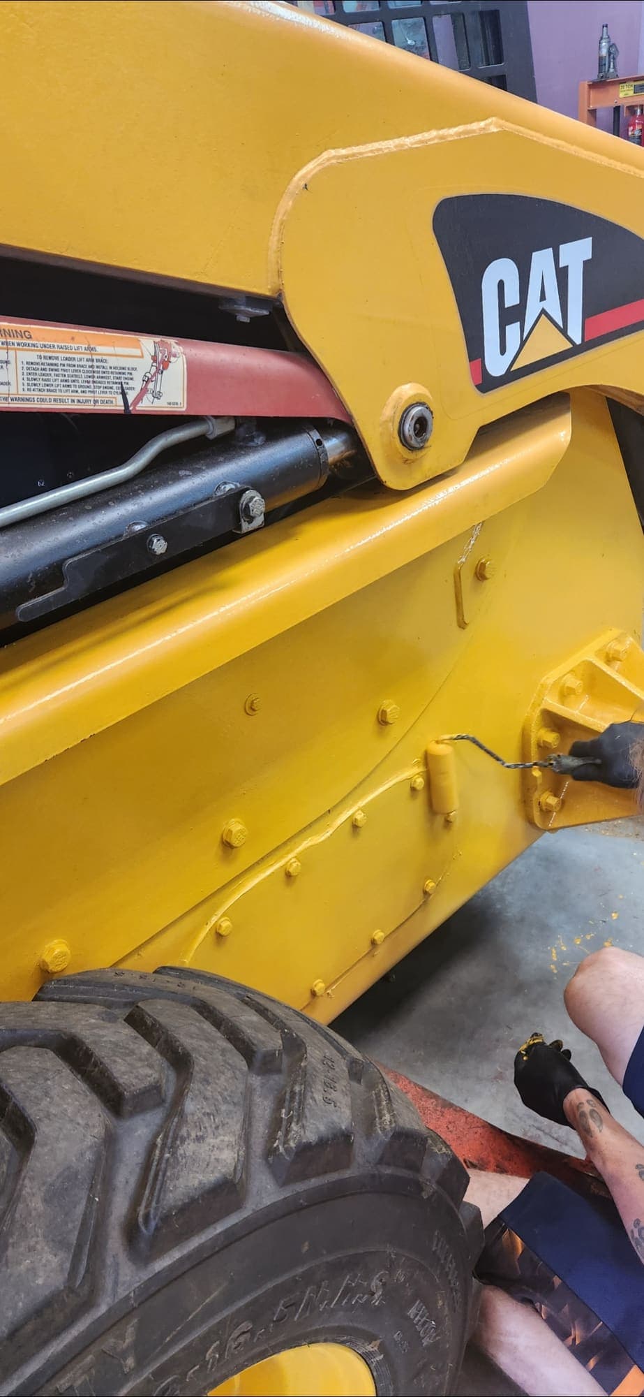 Repainting a CAT skid steer in the shop