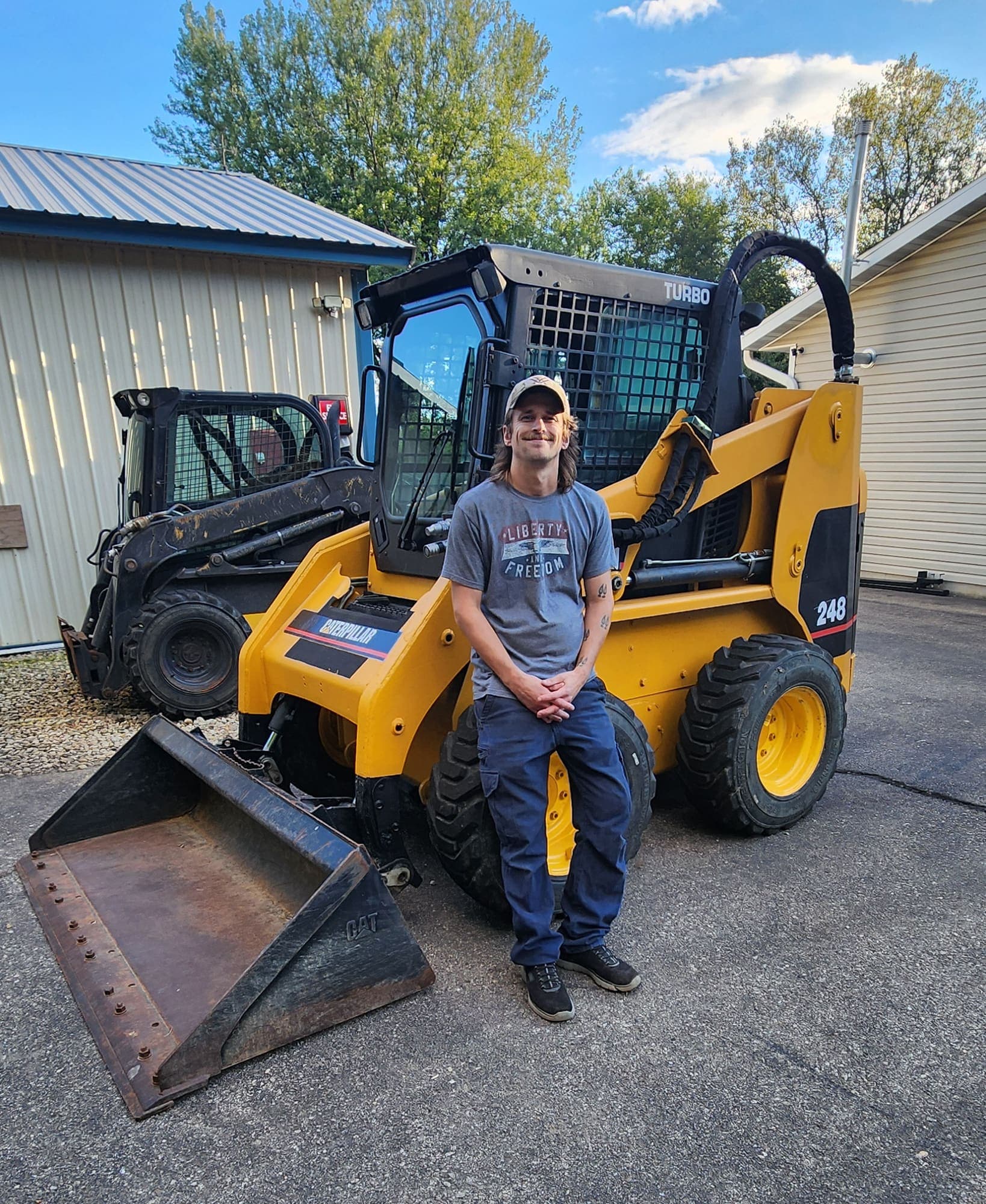Andy sitting on an equipment lift at the shop