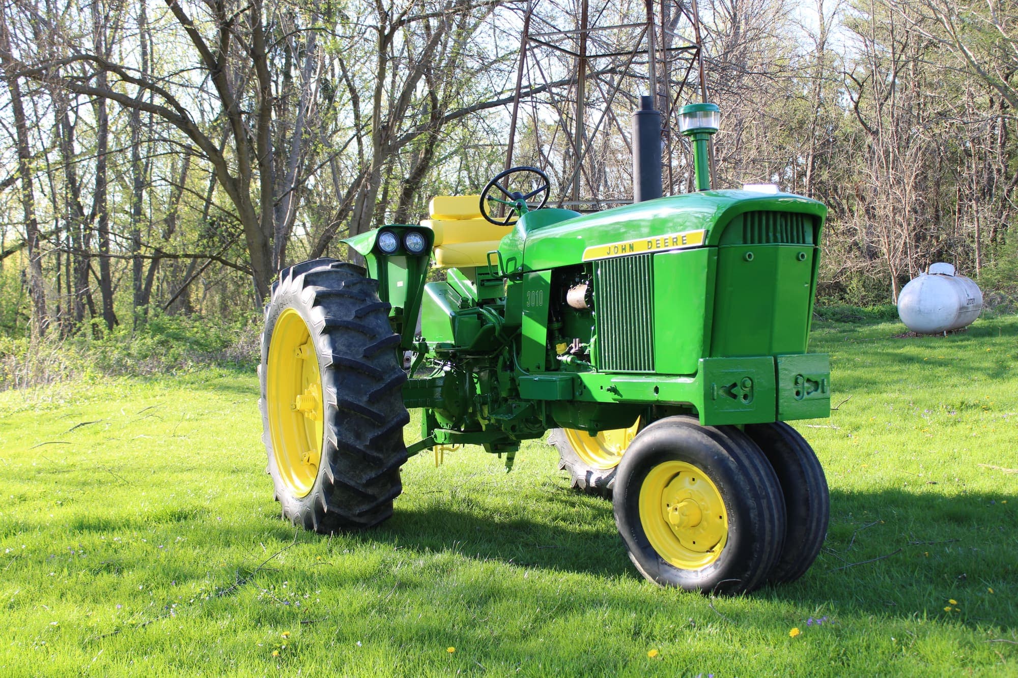 Restored John Deere 3010 parked on the grass, fresh green and yellow paint