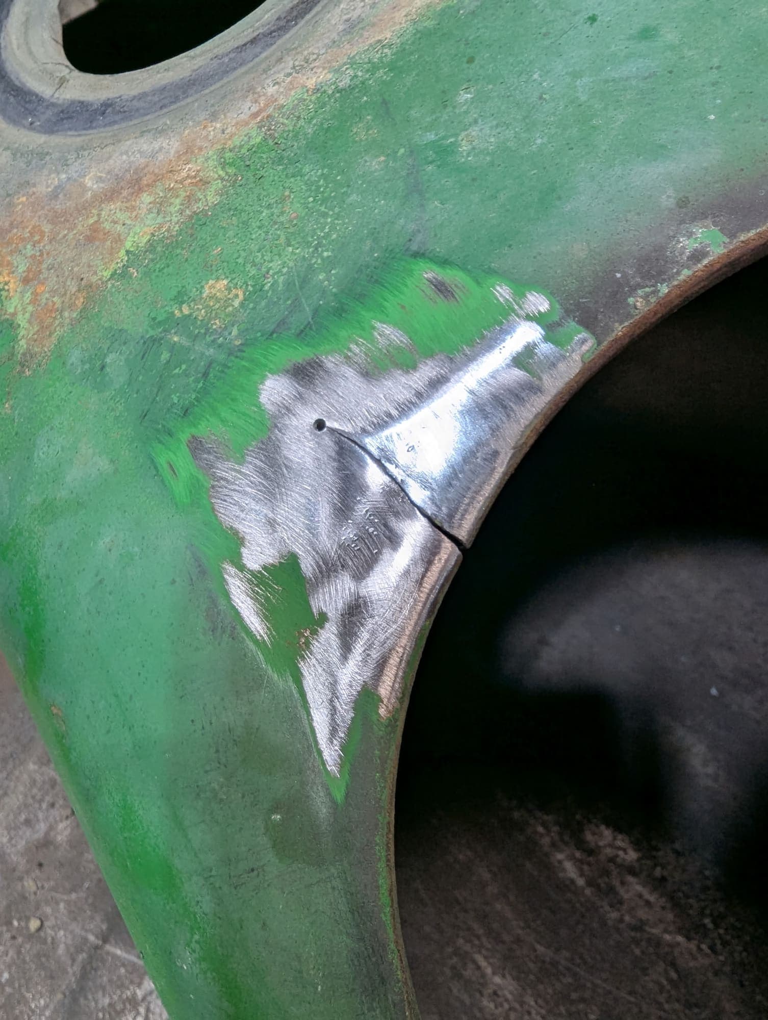 Crack in tractor sheet metal, sanded down to bare steel before welding
